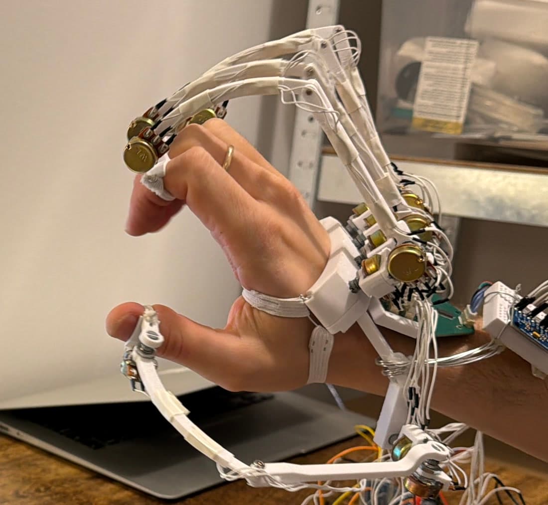 The glove worn on a hand: rotary potentiometers at the finger joints and thumb linkage, with the wrist-mounted board behind